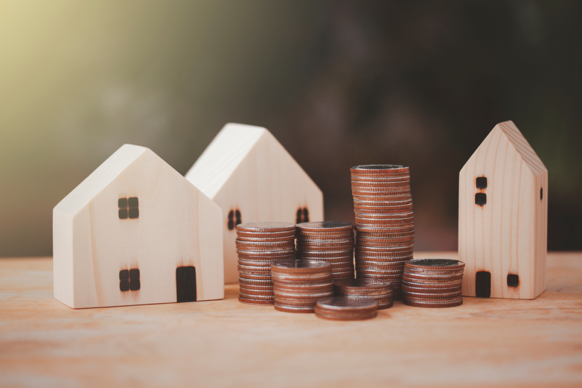 Investissement locatif en couple – Des petites maisons en bois avec des piles de pièces