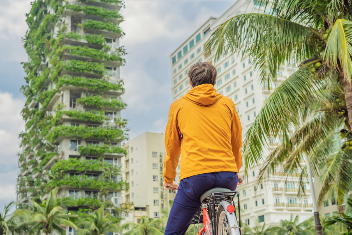définition écoquartier – un homme en vélo devant un immeuble durable